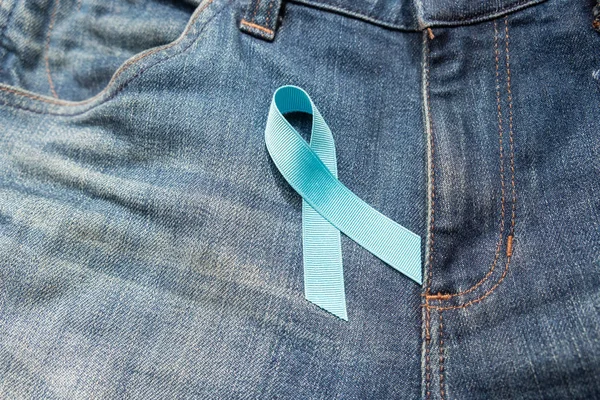 Prostate Cancer Awareness, light Blue Ribbon on jeans background for supporting people living and illness. Men Healthcare and World cancer day concept