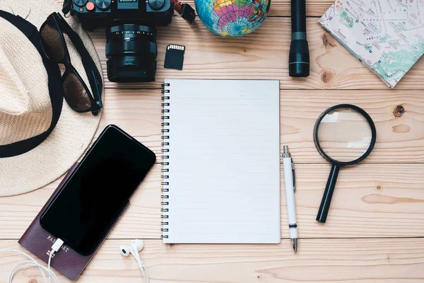 旅行計画のコンセプトの背景 旅行者の付属品 マップ カメラ パスポート 懐中電灯 スマート携帯電話 サングラス 木製のテーブルの上にペンとノート トップ — ストック写真