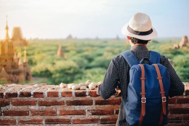 Şapkalı, Pagoda üzerinde duran ve güzel antik tapınak, işareti ve popüler turistik Bagan, Myanmar için arıyorsunuz Asya seyahat seyahat backpacker genç adam. Asya seyahat kavramı