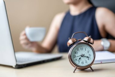 Pazarlama planı ve sabahları kahve içme dizüstü bilgisayar analizi ile genç iş kadını ile çalar saat kadar yakın. İş, finans ve yaşam tarzı kavramları