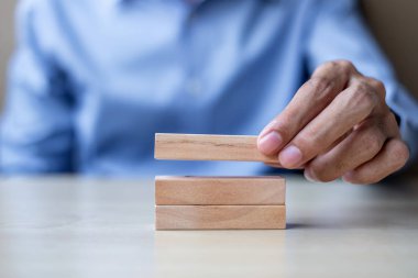 Ahşap yapı taşları tablo arka planda tutan işadamı el. İş planlama, Risk Yönetimi, çözüm ve strateji kavramları