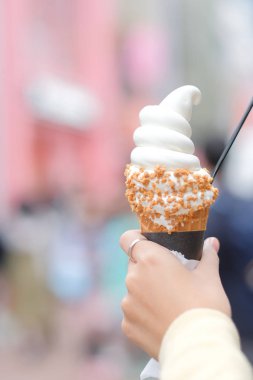 Kadın el dondurma waffle koni şehir arka planda tutarak