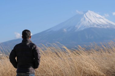 Ayakta ve güzel Mount Fuji ile arayan adam seyahat çok Milli olmuş ve mavi gökyüzü göl kawaguchiko, Japonya, kar. işareti ve turistik için popüler. seyahat kavramı