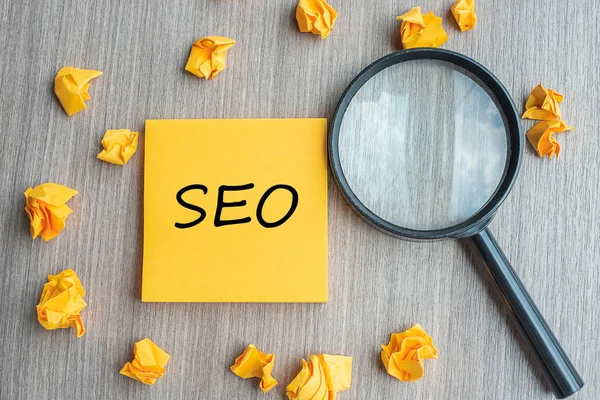 SEO (Search Engine Optimization) palabras en nota amarilla con miga — Foto de Stock
