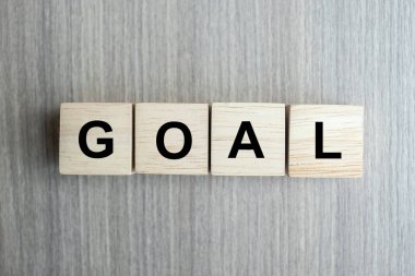 Masa arkasında Goal metni olan tahta küp. Başarı, strateji