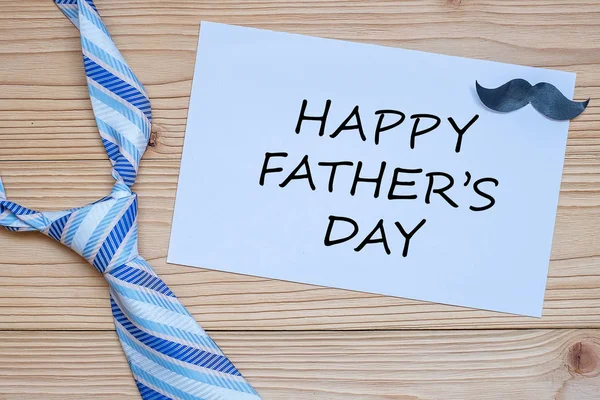 Счастливого Дня отца с голубыми галстуками и усами на деревянном пакете — стоковое фото