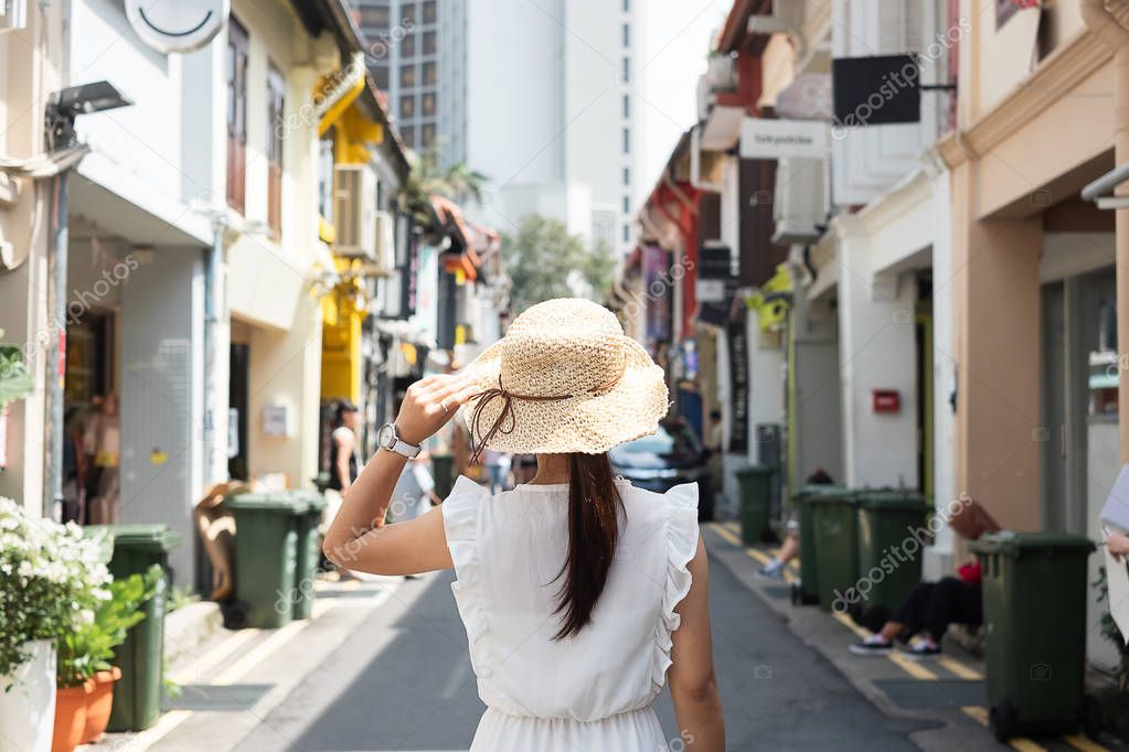 Young woman traveling with white dress and hat, happy Asian trav