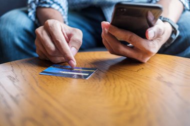 Genç sıradan bir iş adamı kredi kartı tutuyor ve touchscr kullanıyor.