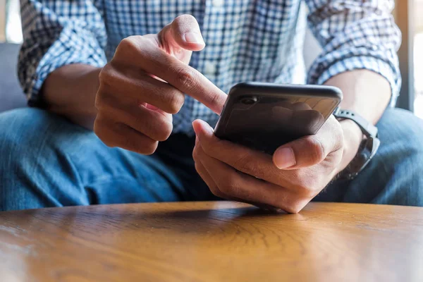 Joven hombre de negocios casual sosteniendo y utilizando el teléfono inteligente para sms me — Foto de Stock