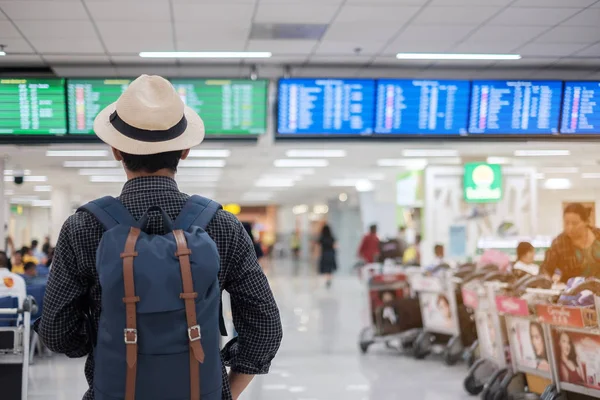Młody człowiek podróżnik z kapeluszem sprawdzanie czasu lotu, Asian passenge — Zdjęcie stockowe