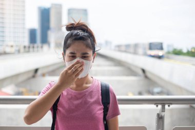 N95 solunum maskesi takan genç Asyalı kadın korumak ve filte