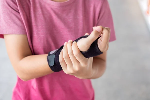 Junge Frau hält ihre Handgelenksschmerzen, weil mit dem Computer lange t — Stockfoto