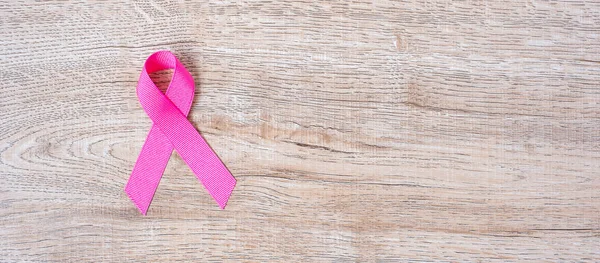 October Breast Cancer Awareness month, Pink Ribbon on wood backg