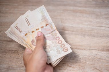 Thai Baht banknot yığınını tutan işadamı el. iş, mon