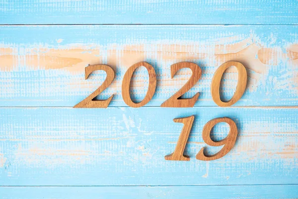 change 2019 to 2020 number on wood background. Resolution, strat