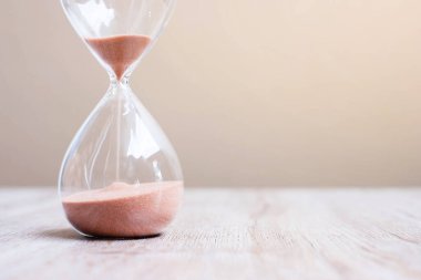Masadaki kum saati kum saati, geçen zamanı ölçen kum saati ampulünden akıyor. Geri sayım, teslim tarihi, yaşam süresi ve emeklilik kavramı