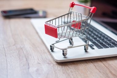 Ev ofisinde dizüstü bilgisayarda alışveriş arabası. iş, e-ticaret, teknoloji, e-ticaret, dijital bankacılık ve çevrimiçi ödeme kavramı