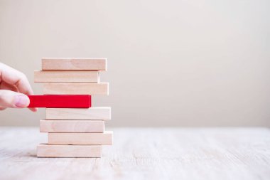 İşadamı eli kuleye kırmızı tahta bloğu yerleştiriyor ya da çekiyor. İş planlaması, Risk Yönetimi, Çözüm, Çözüm ve Strateji Kavramları