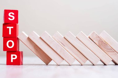 Kırmızı DUR küp blokları masaya düşmeyi durdurur. Sonbahar İşletmeleri, Planlama, Risk Yönetimi, Çözüm, Sigorta ve Strateji Konseptleri