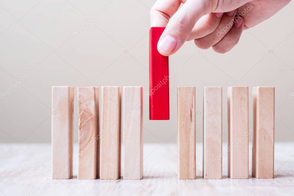 Businessman hand placing or pulling Red wooden block on table. Business planning, Risk Management, Solution, leader, strategy, different and Unique Concepts