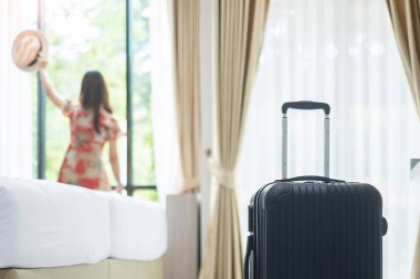 Modern otel odasında, mutlu, genç bir kadın pencereyi açıyor, Asyalı kadın turist güzel doğa manzarasına bakıyor. Seyahat, rahatlama, yolculuk, gezi ve tatil kavramları zamanı
