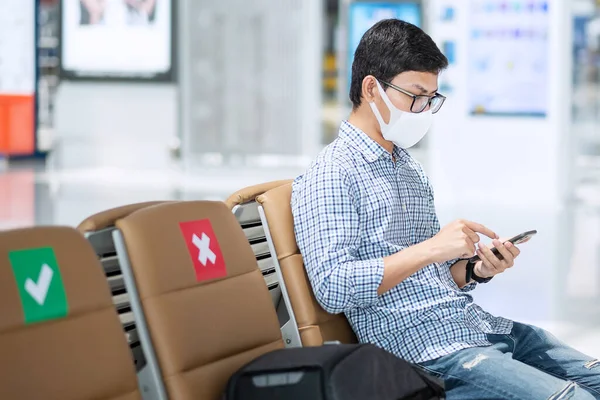 Młody Mężczyzna Masce Twarzy Pomocą Mobilnego Smartfona Lotnisku Ochrony Choroby — Zdjęcie stockowe