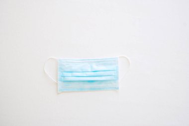 Beyaz yataktaki tıbbi yüz maskesi, Corona Virüsü veya Corona Virüsü Hastalığını önler (Covid-19). Antiseptik, kişisel hijyen, yeni normal, güvenli seyahat ve sağlık konsepti