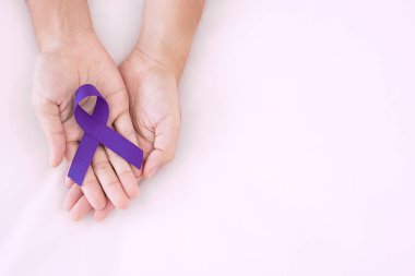 Pankreas kanseri, dünya alzaymır, epilepsi, lupus ve aile içi şiddet günü farkındalık ayı, yaşayan insanları desteklemek için mor kurdele tutan kadın. Sağlık ve Dünya Kanser Günü konsepti