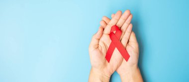 Red Ribbon 'ı yaşayan ve hastalıkları desteklemek için tutan adam. Sağlık ve güvenli seks konsepti. Aralık Dünya Yardım Günü Farkındalık Ayı
