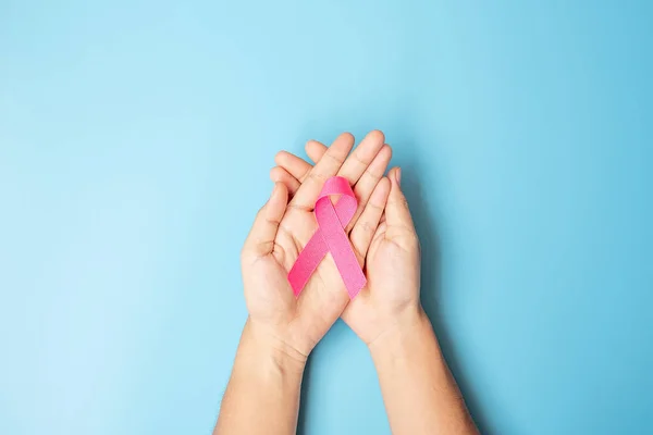 十月乳腺癌意识月 成年女性手牵着带蓝色背景的粉红丝带 以支持人们生活和生病 国际妇女 母亲和世界癌症日概念 — 图库照片