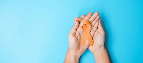 Leukemia, Kidney cancer day, world Multiple Sclerosis, CRPS, Self Injury Awareness month, woman holding Orange Ribbon for supporting people living and illness. Healthcare and World cancer day concept