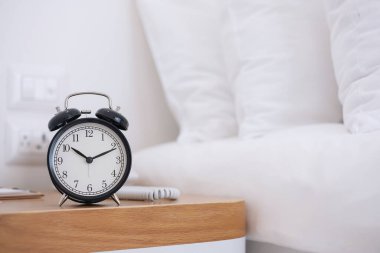 Gece yatak odasındaki masada siyah Retro alarm saati, uyku ve günlük rutin konsept