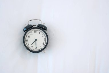Siyah alarmlı saat sabah yatakta, uyan, rahatla, iyi günler ve günlük konsept
