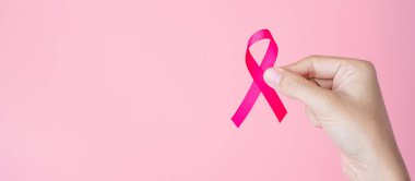 Ekim Kanser Farkındalığı Ayı, pembe arka planda Pembe Kurdele tutan Yetişkin Kadın Yaşayan ve Hastalıkları Desteklemek İçin. Uluslararası Kadınlar, Anne ve Dünya Kanser Günü Konsepti