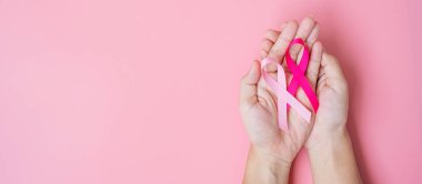 Ekim Kanser Farkındalığı Ayı, pembe arka planda Pembe Kurdele tutan Yetişkin Kadın Yaşayan ve Hastalıkları Desteklemek İçin. Uluslararası Kadınlar, Anne ve Dünya Kanser Günü Konsepti