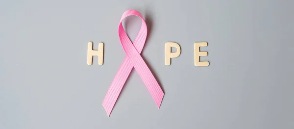 October Breast Cancer Awareness month, Pink Ribbon with HOPE text on grey background for supporting people living and illness. International Women, Mother and World cancer day concept