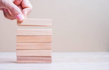 İşadamı kuleye tahta bloğu yerleştiriyor ya da çekiyor. İş planlaması, Risk Yönetimi, Çözüm, Sigorta ve Strateji Konseptleri