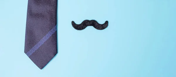 blue neckties and mustache on blue background. Happy Father\'s Day and International Men\'s Day concepts