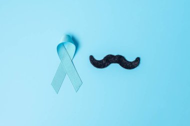 November Prostate Kanser Farkındalığı Ayı, açık mavi kurdeleli, tahta arka planda yaşayan ve hastalıkları destekleyen insanlar. Daha ileri, uluslararası erkekler günü ve dünya kanser günü konsepti