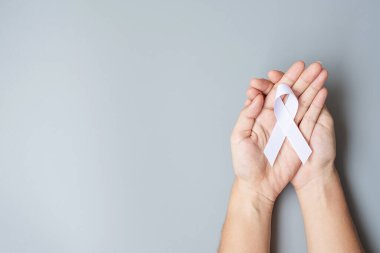 November Lung Kanser Bilinci Ayı, Demokrasi ve Uluslararası Barış Günü. Gri arkaplanda beyaz kurdele tutan adam