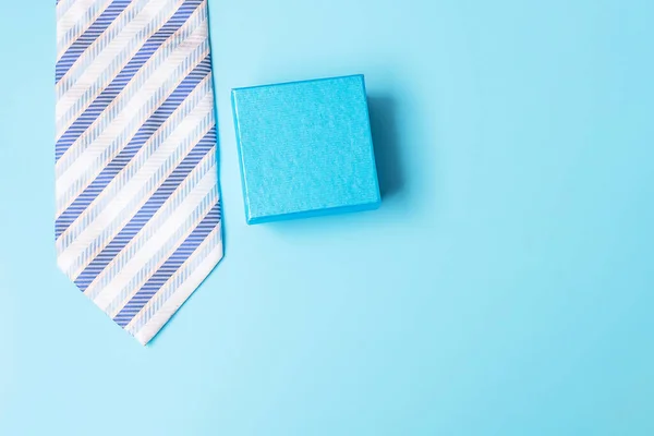 gift box with and necktie on blue background, preparation for father. World International men day and Fathers day concept