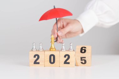 Yeni yılın kutlu olsun, elinde kırmızı şemsiyeyle satranç oynayan insanlar. hayat sigortası, sağlık sigortası, liderlik, koruma, güvenlik ve yeni yıl tatili kavramları