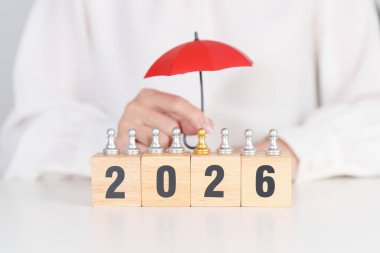 Yeni yılın kutlu olsun, elinde kırmızı şemsiyeyle satranç oynayan insanlar. hayat sigortası, sağlık sigortası, liderlik, koruma, güvenlik ve yeni yıl tatili kavramları