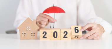 Yeni yılın kutlu olsun, kırmızı şemsiyeyle. Sigorta, gayrimenkul, konut kredisi, vergi, yatırım, mortgage, finans, tasarruf, koruma ve güvenlik 