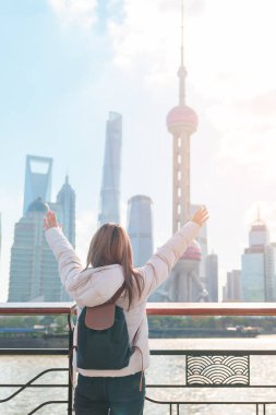 Çin, Şangay 'ı ziyaret eden bir kadın gezgin. Sırt çantalı bayan turist Şangay 'ın kuzeyindeki Lujiazui' nin Şangay manzarasına bakıyor. tarihi eser ve turizm turizmi için popüler.