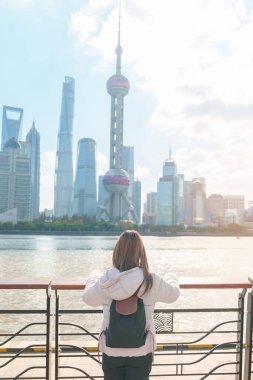Çin, Şangay 'ı ziyaret eden bir kadın gezgin. Sırt çantalı bayan turist Şangay 'ın kuzeyindeki Lujiazui' nin Şangay manzarasına bakıyor. tarihi eser ve turizm turizmi için popüler.