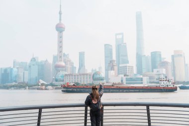 Çin, Şangay 'ı ziyaret eden bir kadın gezgin. Sırt çantalı bayan turist Şangay 'da Lujiazui' nin Şangay manzarasına bakıyor. Şehir simgesi ve turizm turizmi için popüler. Tatil kavramı