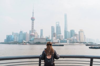 Çin, Şangay 'ı ziyaret eden bir kadın gezgin. Sırt çantalı bayan turist Şangay 'da Lujiazui' nin Şangay manzarasına bakıyor. Şehir simgesi ve turizm turizmi için popüler. Tatil kavramı