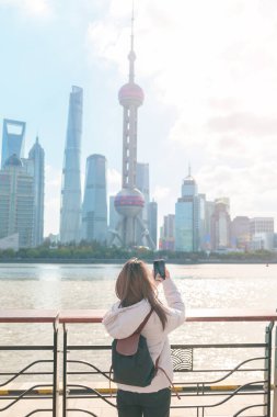 Çin, Şangay 'ı ziyaret eden bir kadın gezgin. Sırt çantalı bayan turist Şangay 'ın kuzeyindeki Lujiazui' nin Şangay manzarasına bakıyor. tarihi eser ve turizm turizmi için popüler.