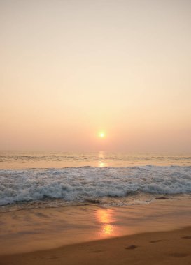 Sahilde okyanus ve dalgalar bakan çarpıcı günbatımı. 
